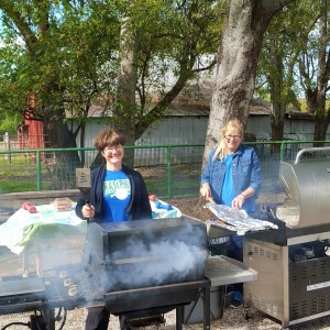 Lara Gajkowski and Kaye Hauschild grill burgers for 150 hungry Middle School students.